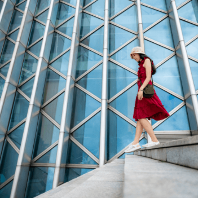 girl walking down steps in front of a modern building