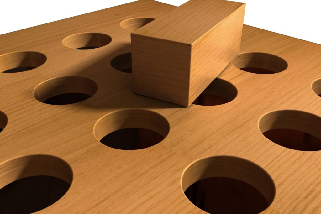 a wooden square peg rests on a board of round holes